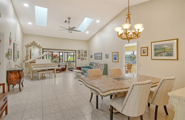 tiled dining room featuring a wealth of natural light, a skylight, ceiling fan, and high vaulted ceiling