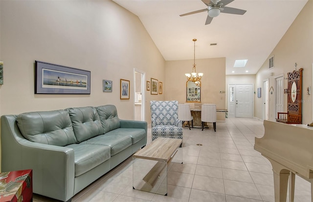 tiled living room featuring ceiling fan with notable chandelier and vaulted ceiling