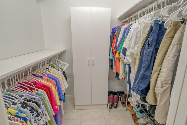 walk in closet with light tile patterned floors