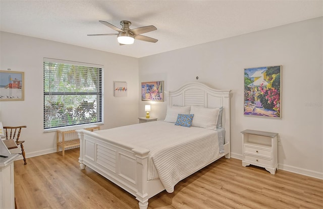 bedroom featuring ceiling fan, a textured ceiling, radiator heating unit, and light wood-type flooring