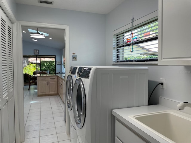 laundry area featuring visible vents, a sink, light tile patterned flooring, washer and dryer, and cabinet space