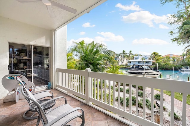 balcony with ceiling fan and a water view