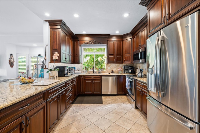 kitchen with backsplash, light stone countertops, light tile patterned floors, and stainless steel appliances