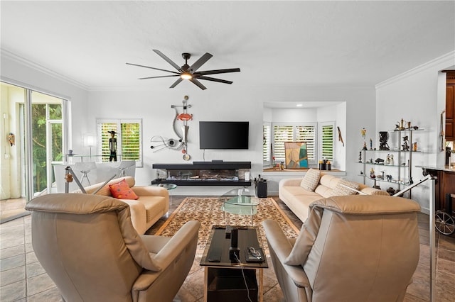 tiled living room with ceiling fan and crown molding