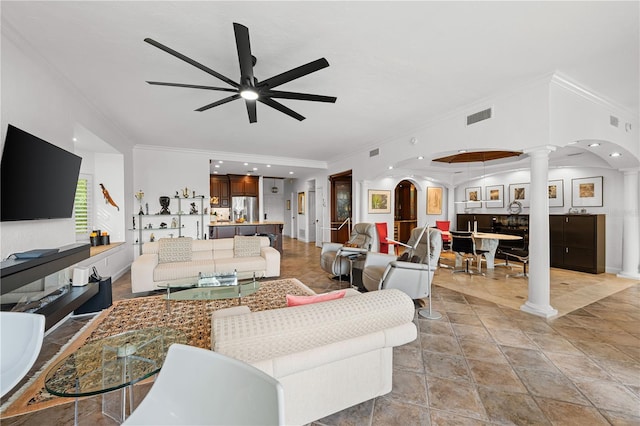 living room with ornate columns, crown molding, and ceiling fan