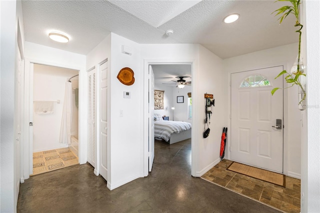 foyer with a textured ceiling and ceiling fan