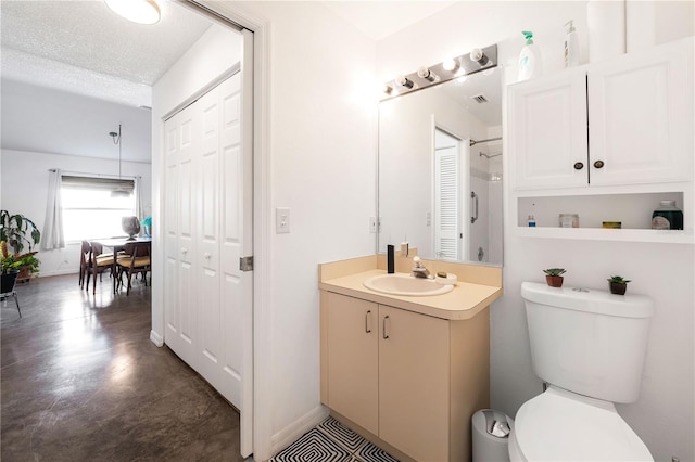 bathroom featuring a textured ceiling, concrete flooring, vanity, and toilet