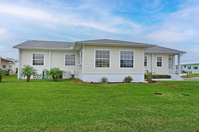 rear view of house featuring a lawn