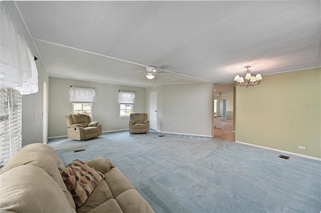 unfurnished living room with ceiling fan with notable chandelier and carpet flooring