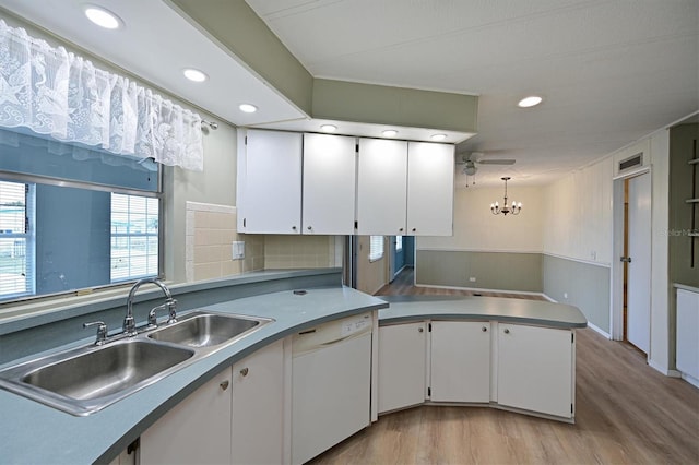 kitchen featuring hanging light fixtures, white cabinets, sink, light hardwood / wood-style flooring, and kitchen peninsula