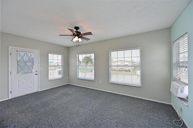 spare room featuring ceiling fan, dark carpet, a textured ceiling, and cooling unit