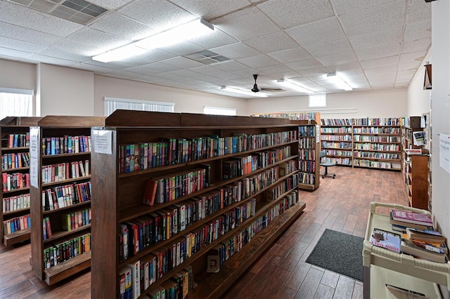 interior space featuring ceiling fan, wood-type flooring, and a drop ceiling