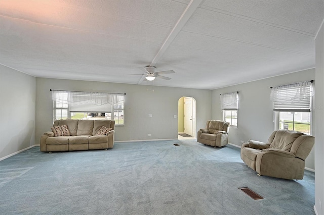 living room with a textured ceiling, carpet flooring, and ceiling fan