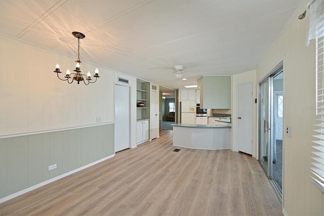 kitchen featuring ceiling fan with notable chandelier, pendant lighting, white fridge with ice dispenser, light hardwood / wood-style floors, and built in features