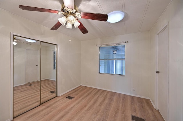 unfurnished bedroom with ceiling fan, a closet, and light hardwood / wood-style flooring