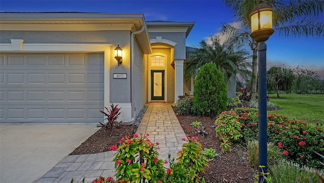 exterior entry at dusk featuring a garage