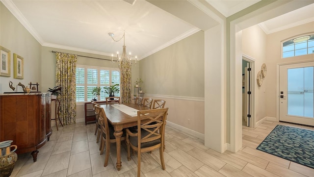 dining space with ornamental molding and a chandelier