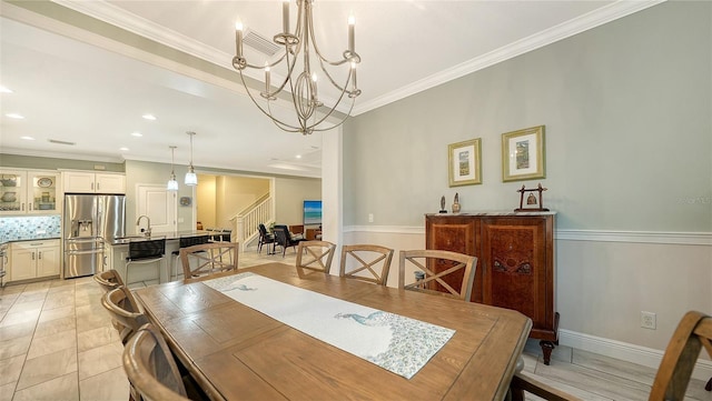 dining room with light tile patterned floors, crown molding, a chandelier, and sink