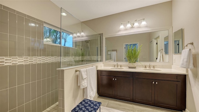 bathroom featuring tile patterned floors, tiled shower, and vanity