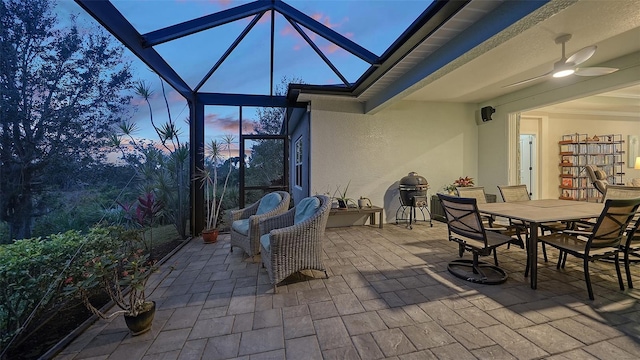 patio terrace at dusk with a lanai and ceiling fan