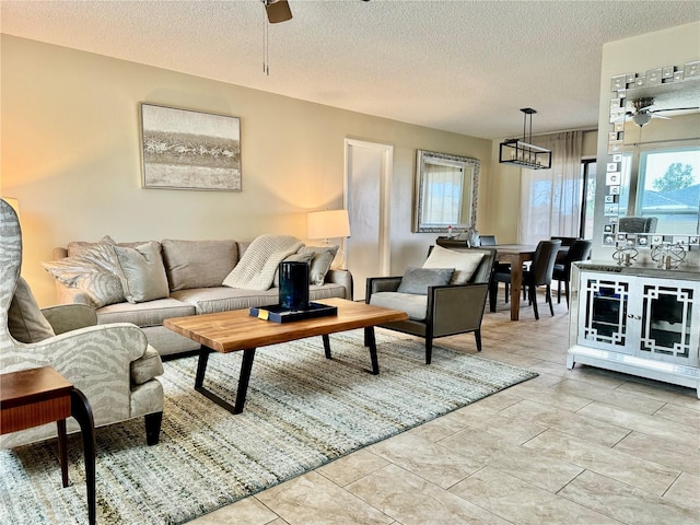 living room with ceiling fan and a textured ceiling