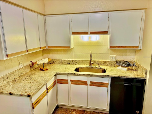 kitchen with dishwasher, white cabinetry, and sink