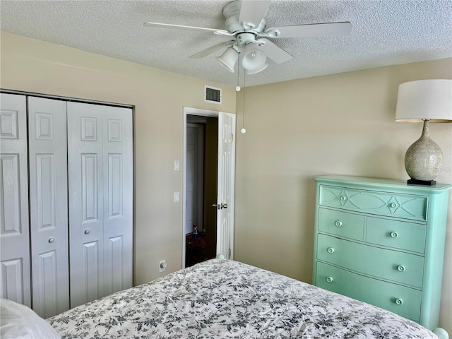 bedroom featuring ceiling fan, a textured ceiling, and a closet