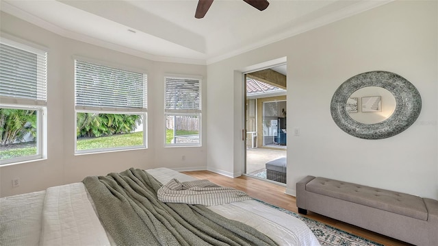 bedroom featuring ornamental molding, light wood finished floors, a ceiling fan, and baseboards