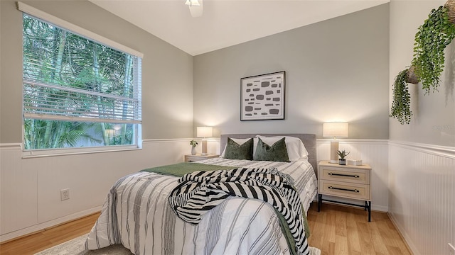 bedroom featuring wainscoting and light wood-style flooring