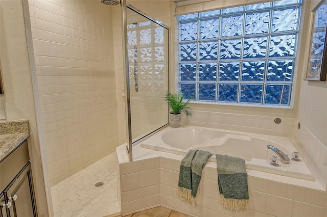 full bathroom with a shower stall, vanity, and a bath