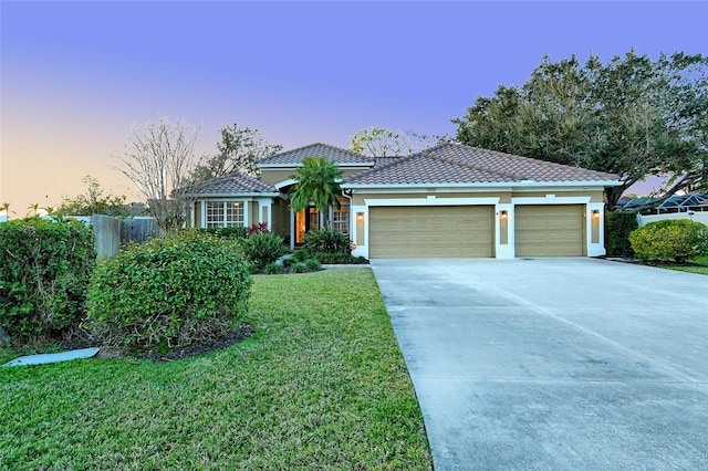 view of front facade featuring driveway, a garage, a tile roof, fence, and a front lawn