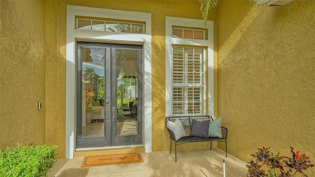 view of exterior entry with french doors and stucco siding