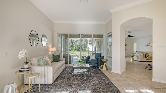 living room with arched walkways, light tile patterned flooring, a ceiling fan, baseboards, and crown molding