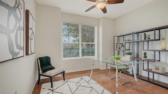 office area with wood finished floors, a ceiling fan, and baseboards