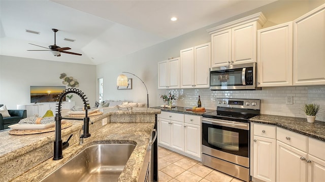 kitchen with light tile patterned floors, a sink, visible vents, open floor plan, and appliances with stainless steel finishes