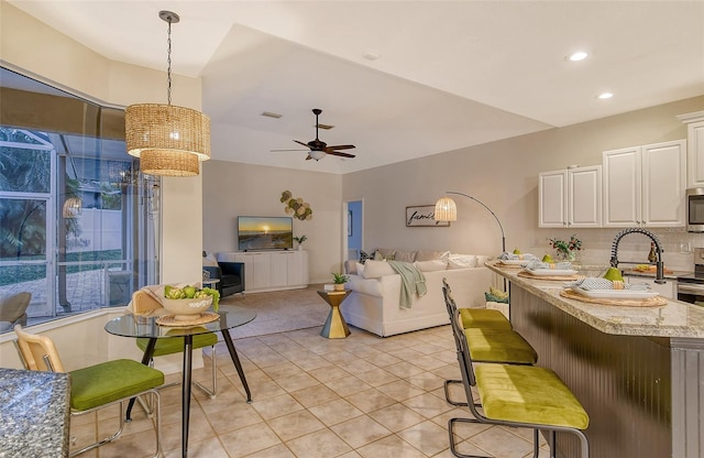 living room featuring light tile patterned floors, ceiling fan, visible vents, and recessed lighting