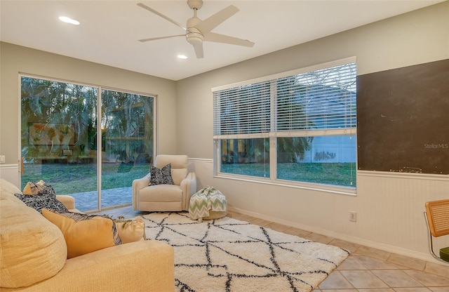 living area with a wainscoted wall, tile patterned flooring, a ceiling fan, and recessed lighting