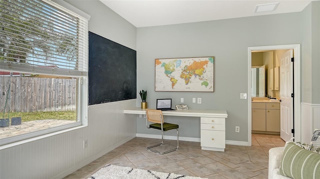 office area with light tile patterned floors, wainscoting, and visible vents