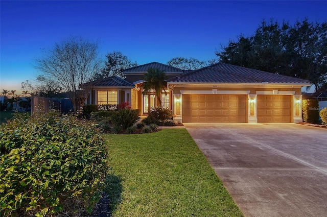 view of front facade with a tile roof, stucco siding, concrete driveway, an attached garage, and a front yard