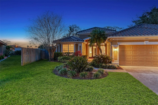 view of front of home featuring a tile roof, fence, a garage, driveway, and a front lawn