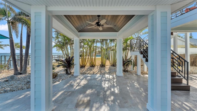 view of patio / terrace with ceiling fan and a water view