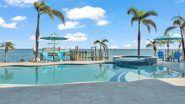 view of swimming pool with an in ground hot tub and a water view