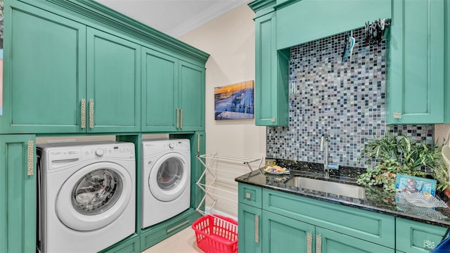 clothes washing area with sink, cabinets, crown molding, and washer and dryer