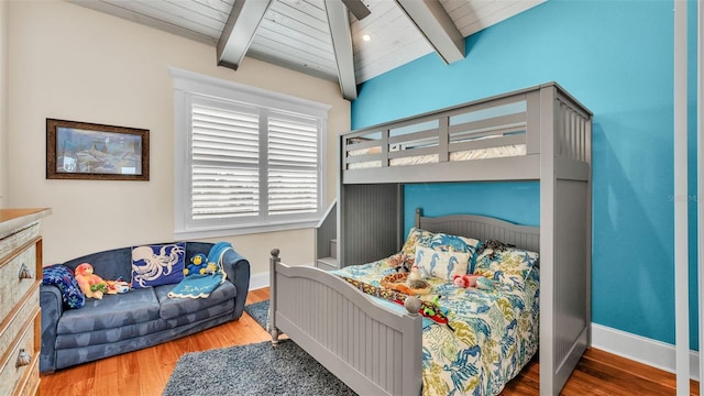 bedroom with lofted ceiling with beams, hardwood / wood-style flooring, and wood ceiling