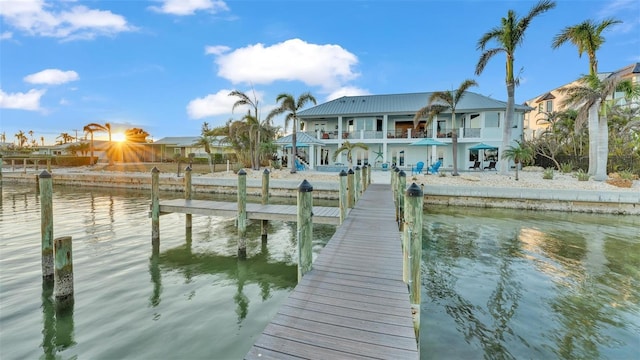 dock area with a balcony and a water view