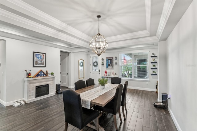 dining room with an inviting chandelier, ornamental molding, dark wood-type flooring, and a tray ceiling