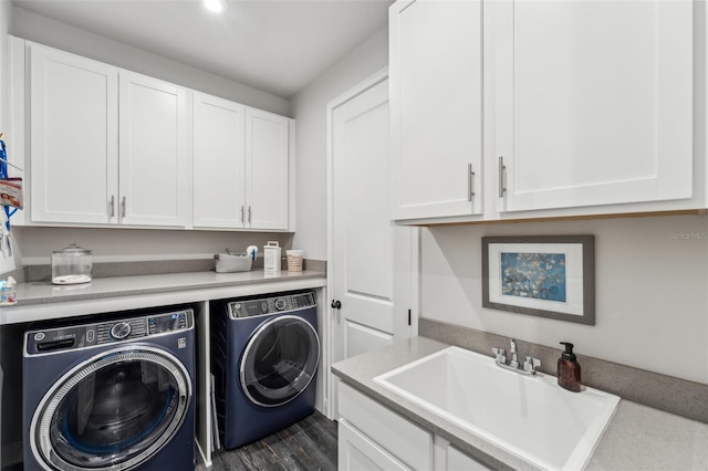 washroom featuring cabinets, sink, washer and dryer, and dark hardwood / wood-style floors