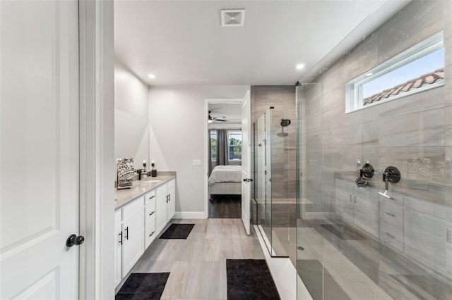 bathroom featuring vanity, walk in shower, and ceiling fan