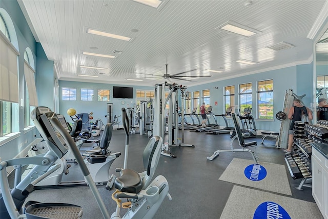 workout area with ceiling fan, ornamental molding, and a wealth of natural light