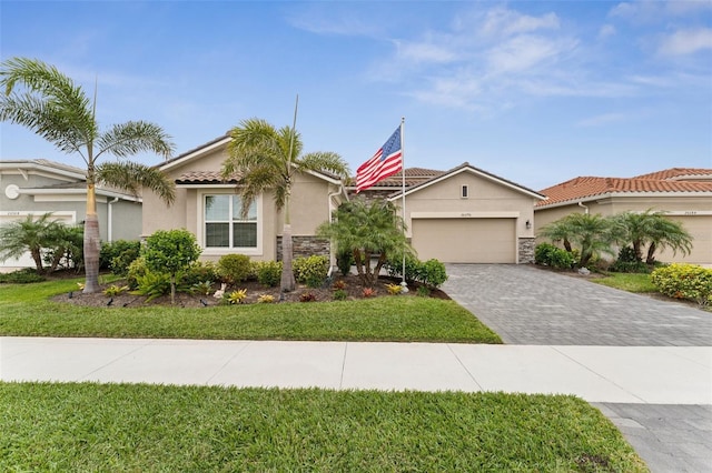 view of front facade featuring stucco siding, decorative driveway, stone siding, a tile roof, and a garage